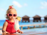 cute little girl drinking cocktail on tropical beach resort