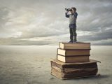 A little is illustrated standing on the books which helps him to see further with his binocular
