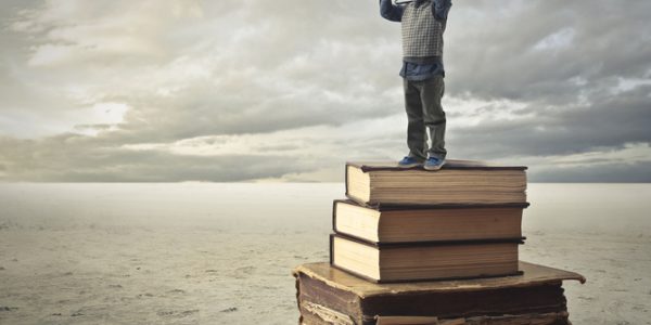 A little is illustrated standing on the books which helps him to see further with his binocular